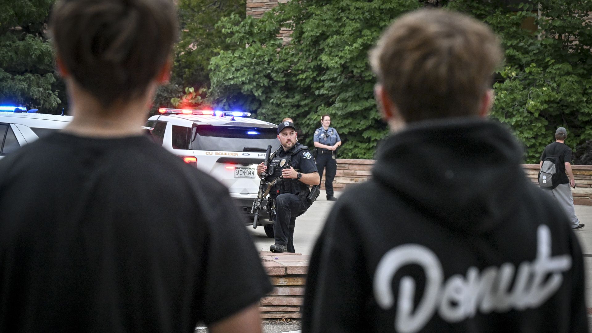 Police block off an area near Norlin Library on the University of Colorado Boulder campus with yellow tape and patrol vehicles.