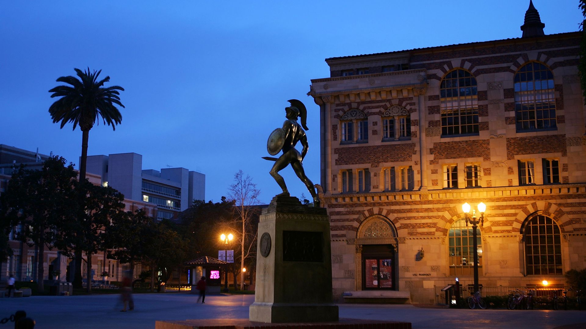 Photo of the USC campus at dusk, with the Trojan statue in the center