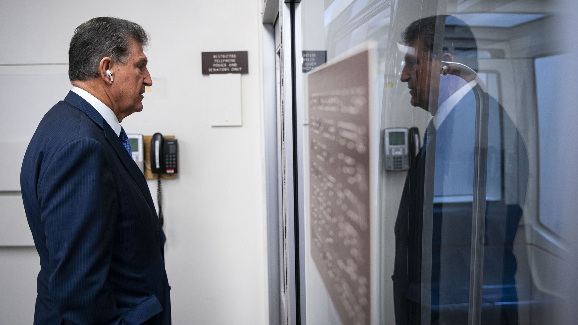 Sen. Joe Manchin and his reflection are seen in a Senate subway car.