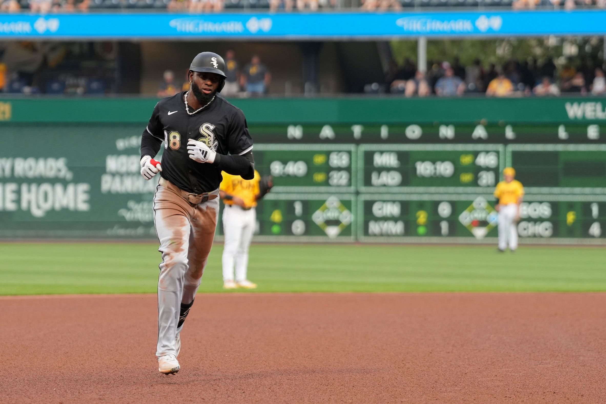 Photo of a baseball player rounding the bases during a game. 