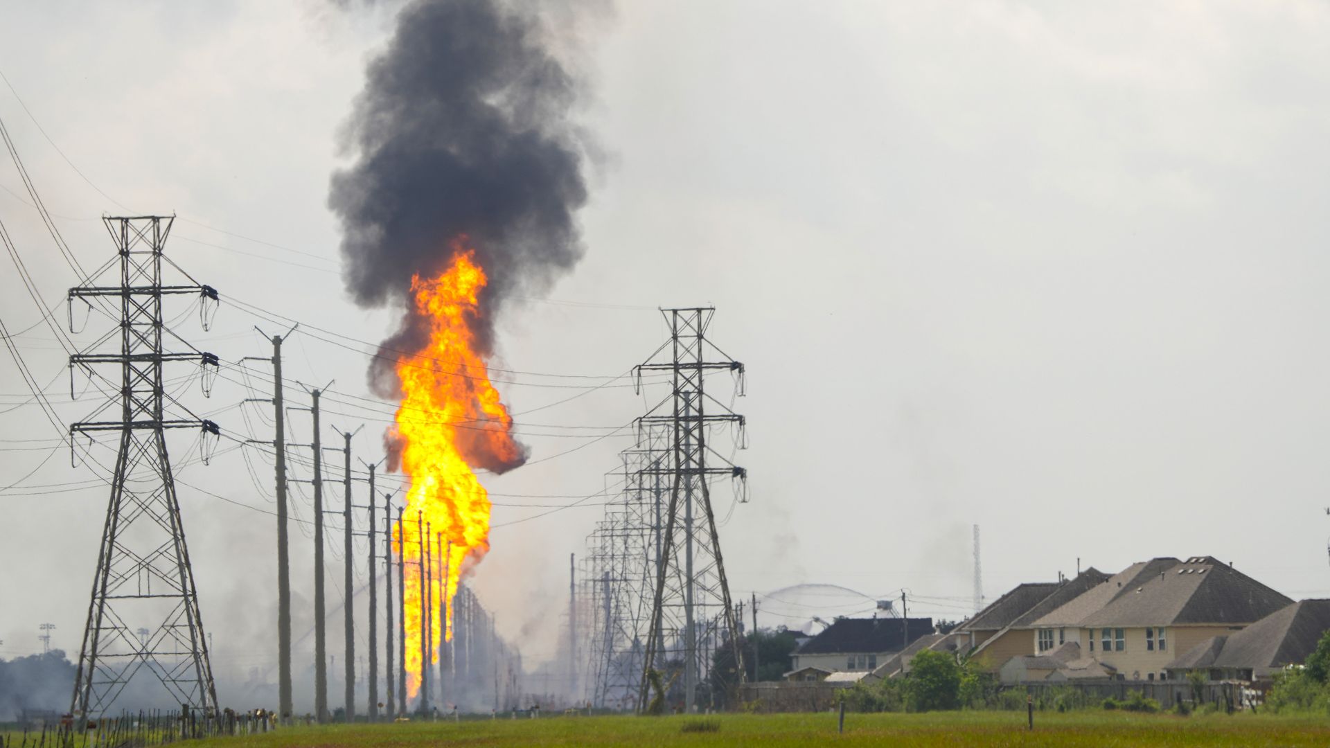 Flames from a ruptured liquid natural gas line shoot into the sky next to a residential neighborhood