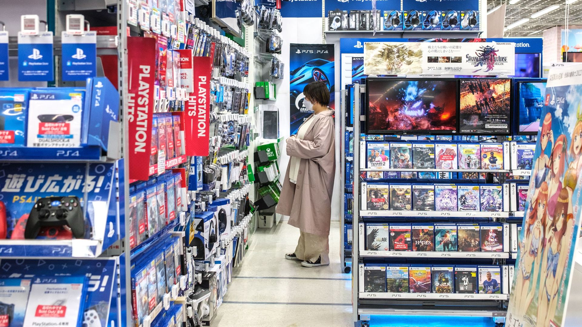Photo of a woman standing in the aisle of a Japanese video game store.