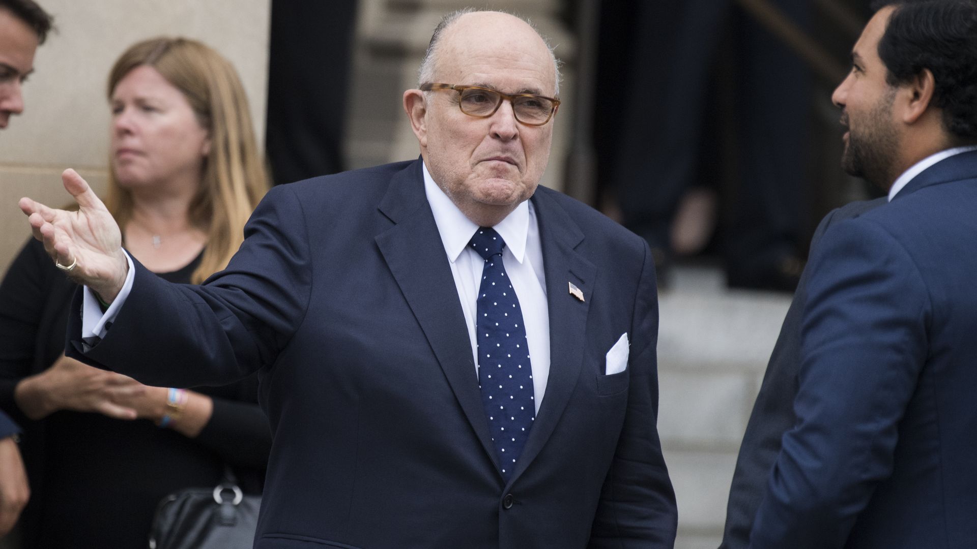 Rudy Giuliani purses lips and raises hand