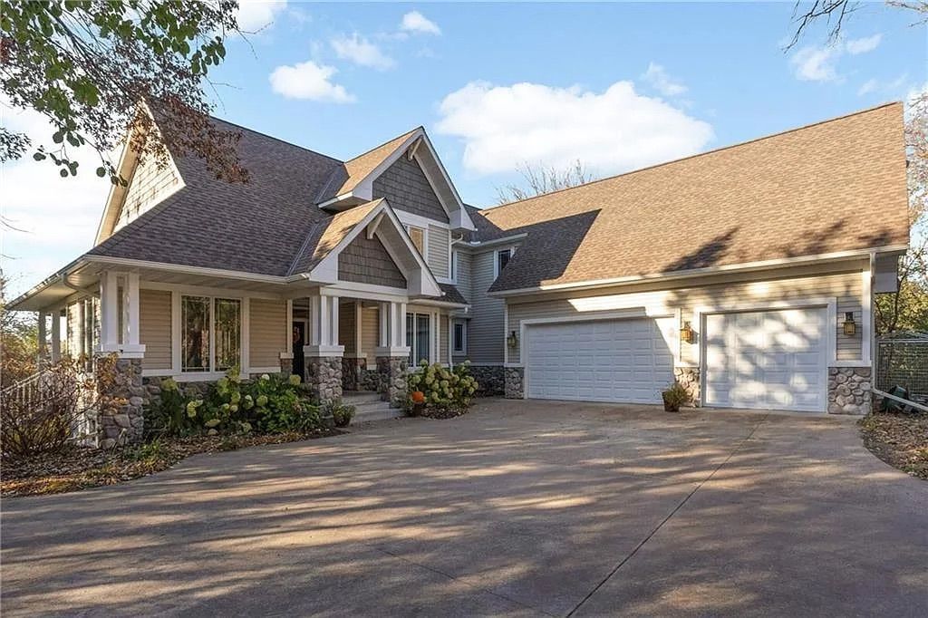 The exterior of a beige home with a slate gray roof. 