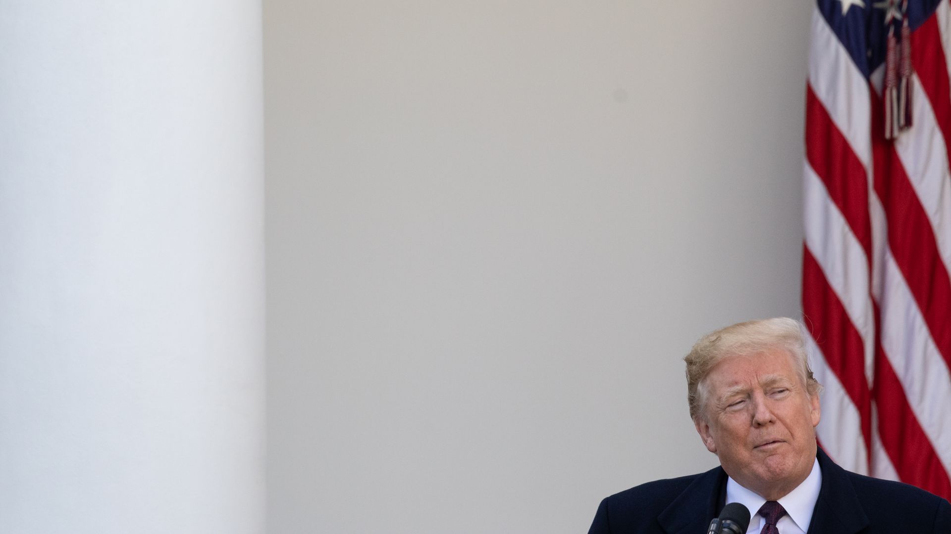 Donald Trump in the bottom right corner of the photograph with an American flag behind him. 