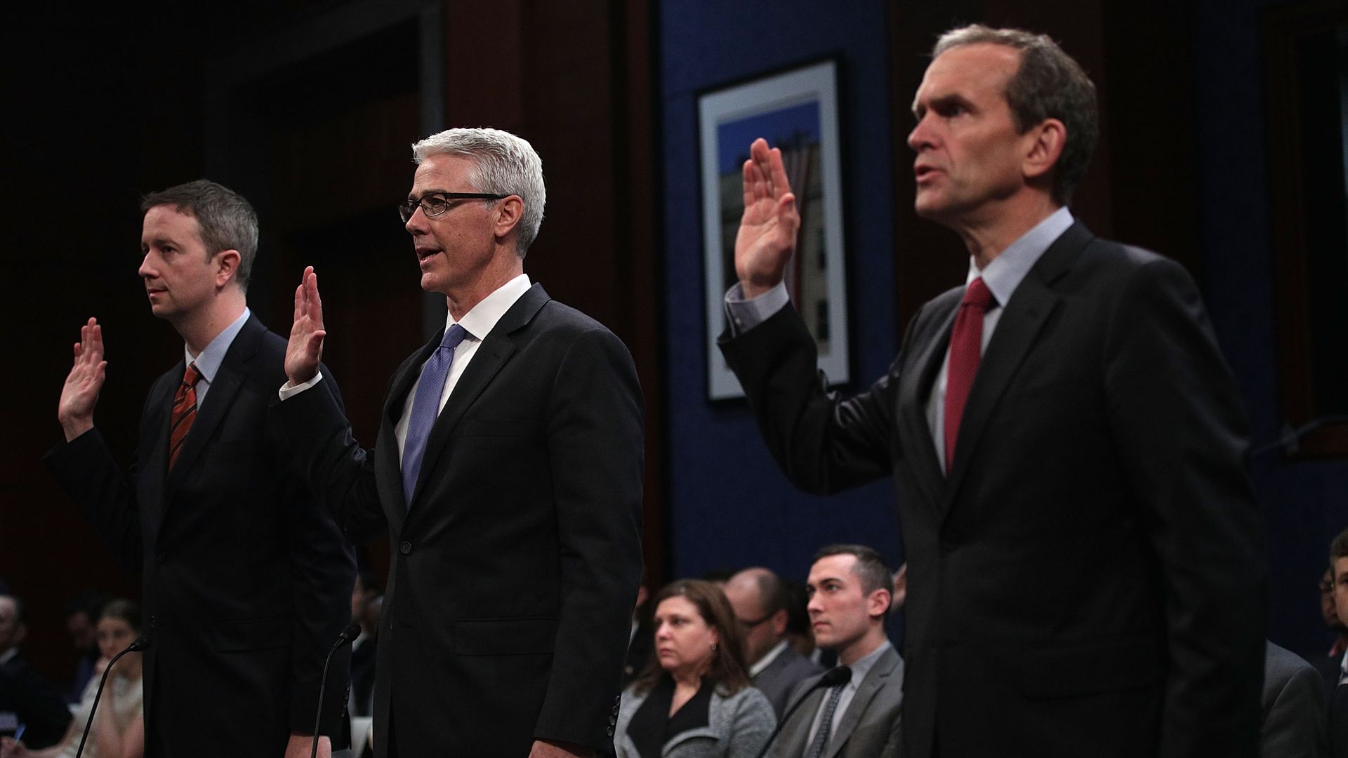 Witnesses from major tech companies raise their right ends to be sworn in before Congress