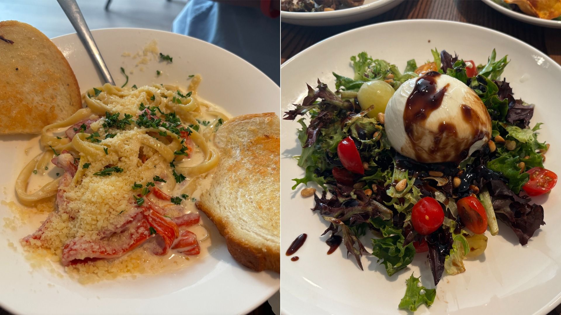 Two plates: one with creamy fettuccine pasta, red bell peppers, parmesan, parsley, and two slices of toasted bread; the other with mixed greens, cherry tomatoes, grapes, seeds, mozzarella, and balsamic glaze.