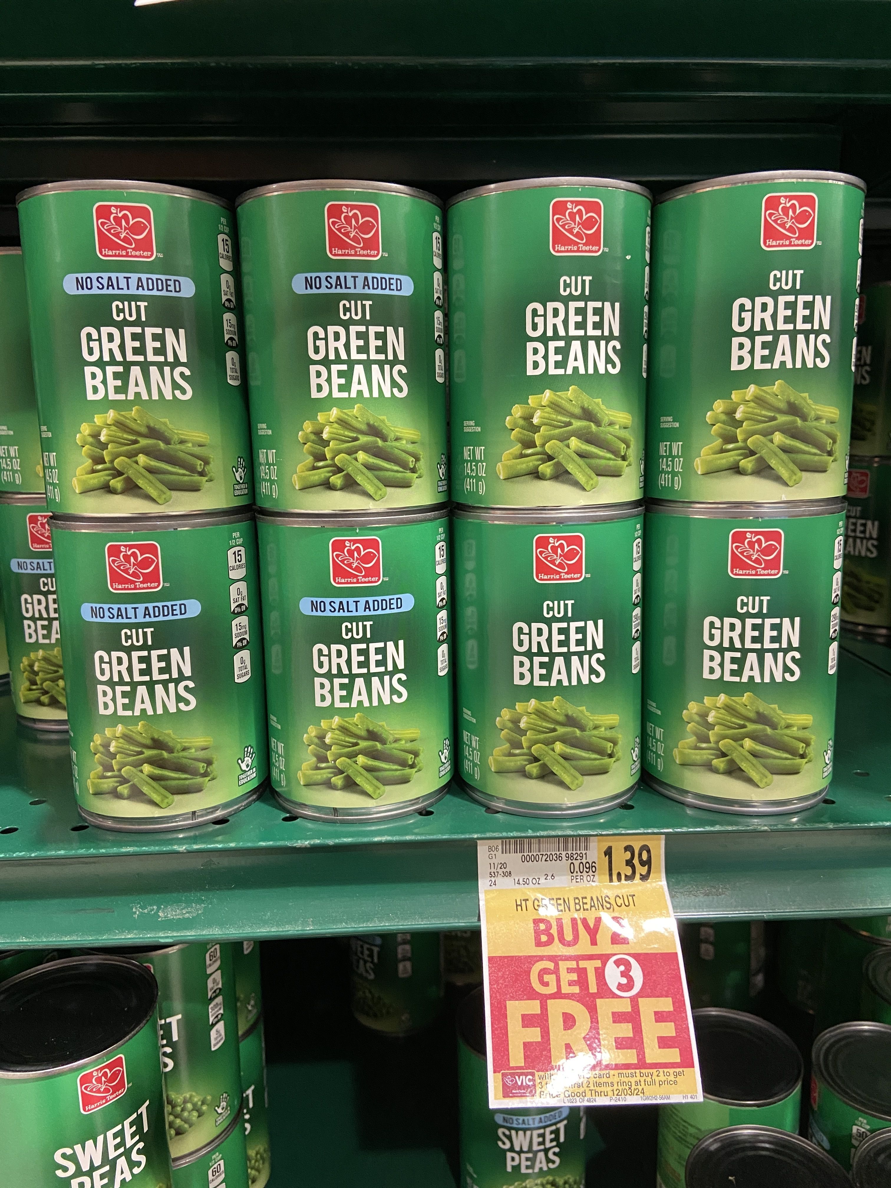 Cans of green beans on a Harris Teeter shelf.