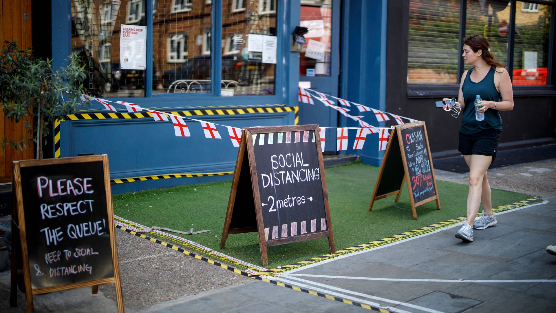 A person walking past shops.
