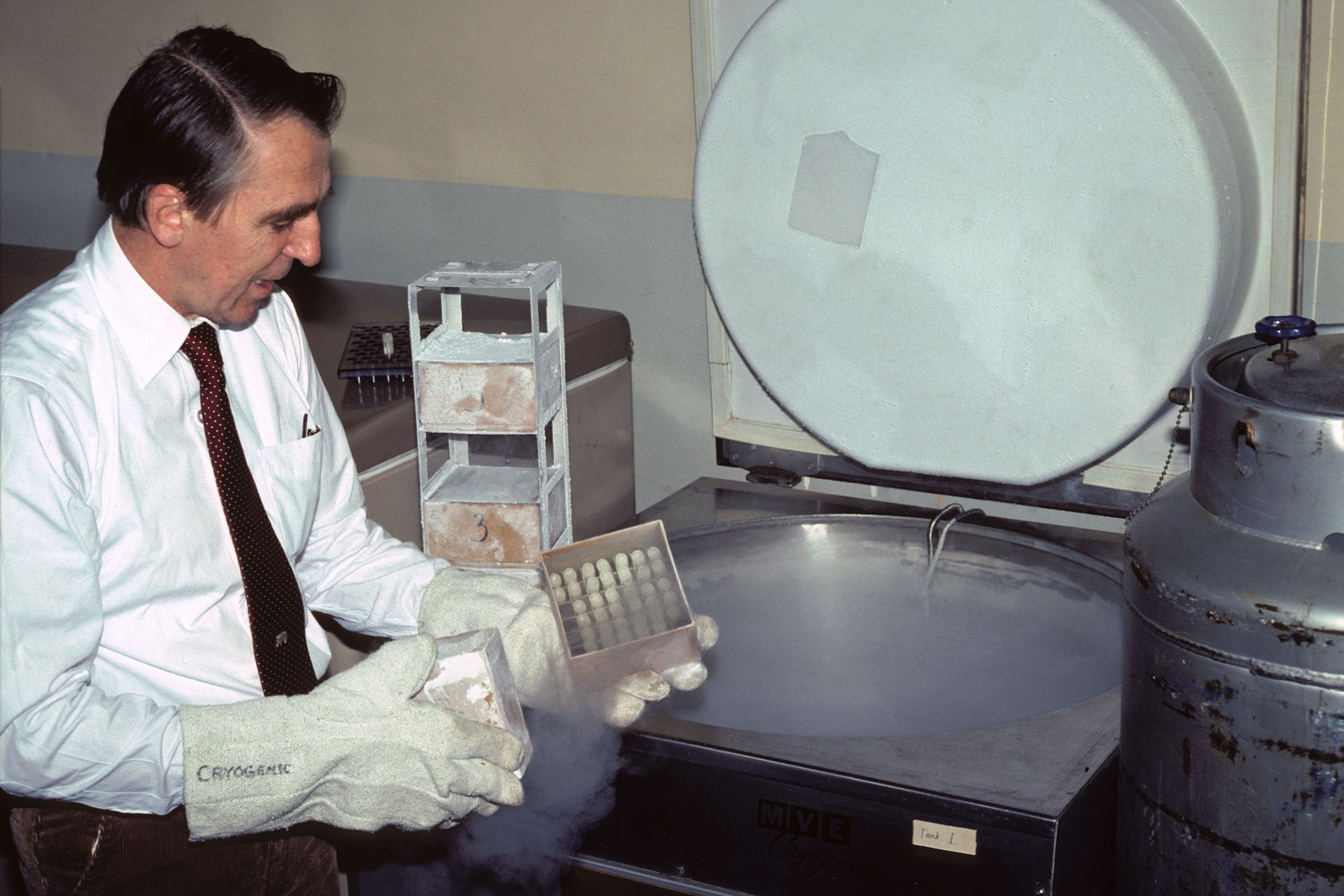 Frozen Zoo founder Kurt Benirschke takes out specimens from a cryochamber in a lab.
