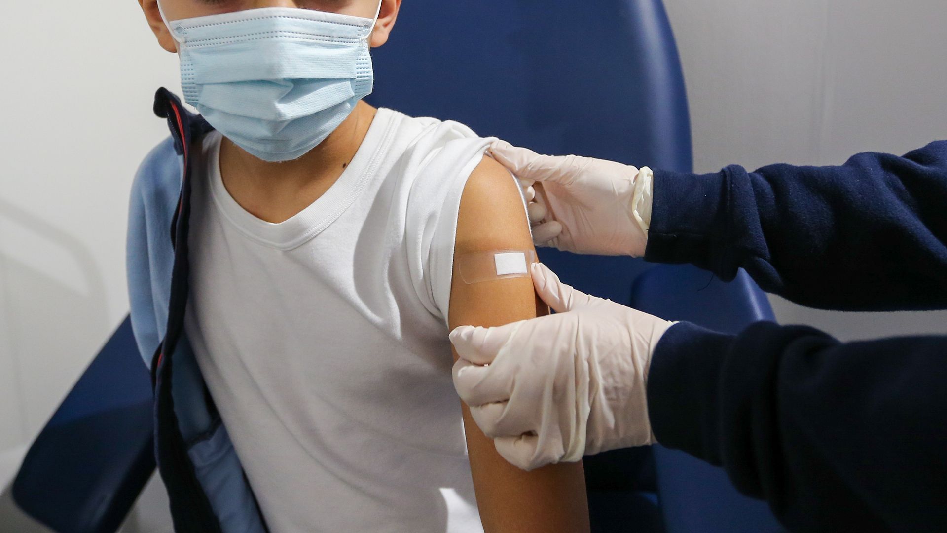 A nurse puts a patch on a child after giving him the vaccine, on the first day of vaccination in Italy for children aged 5 to 11