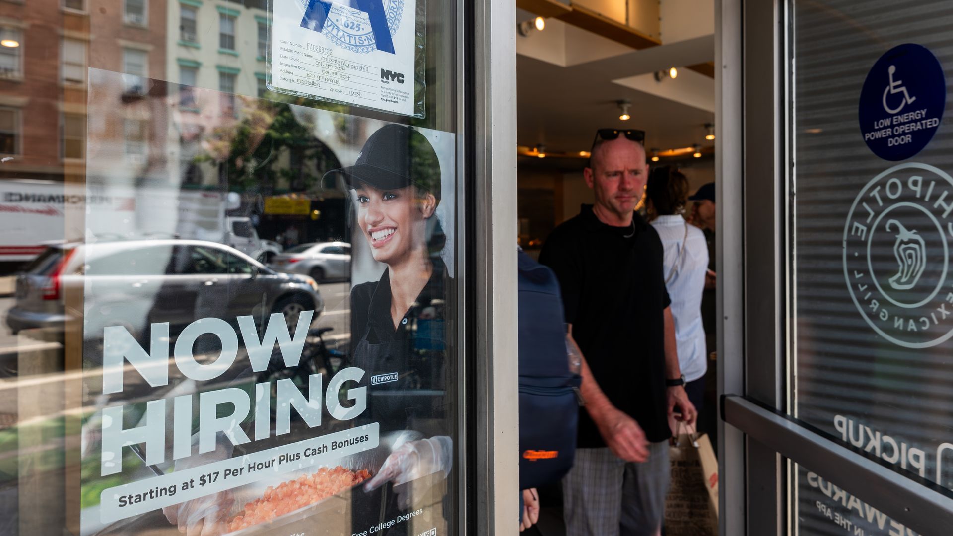 A 'now hiring' sign is displayed in a business window in Manhattan on September 05, 2025 in New York City.