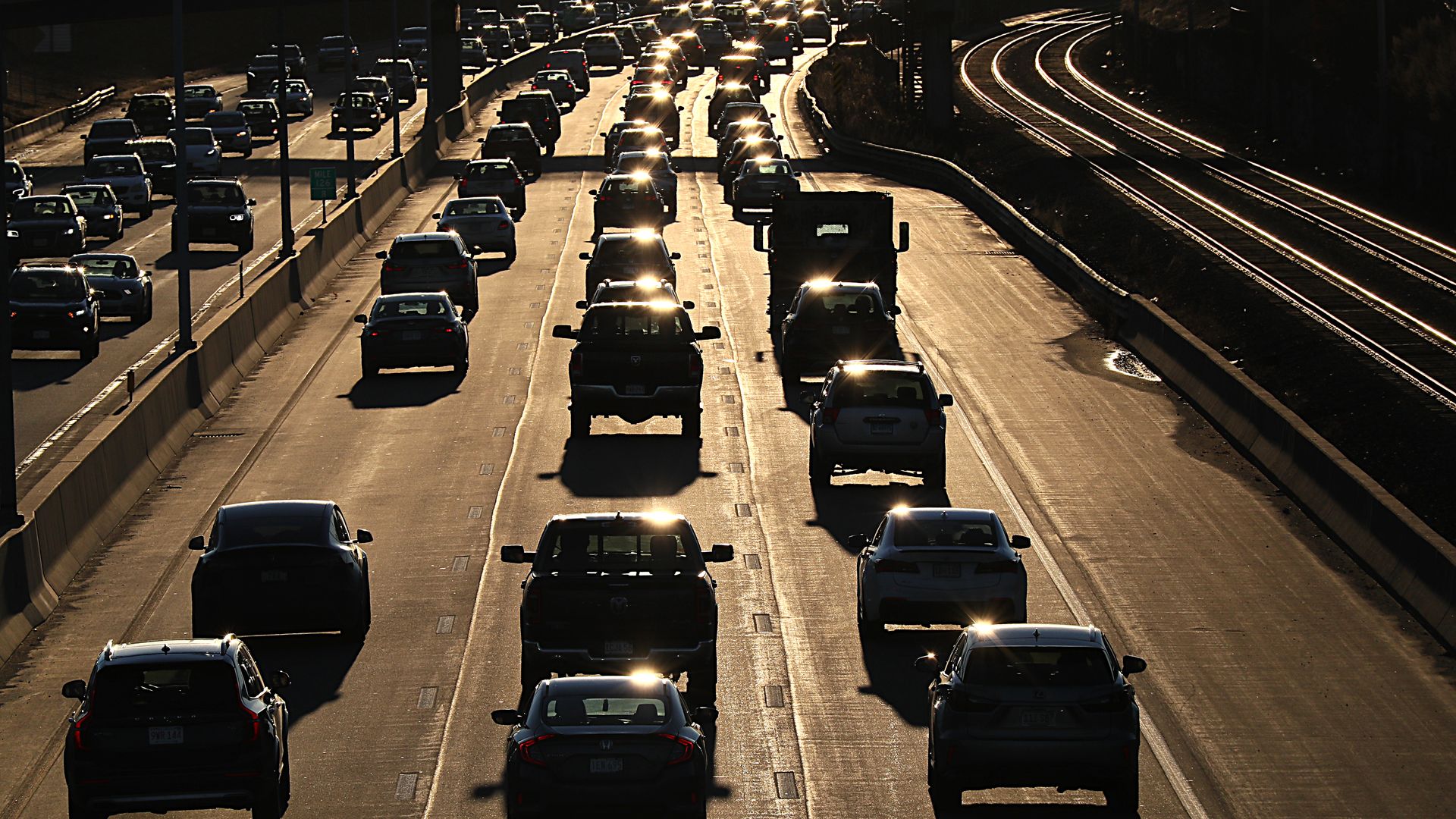 Lines of cars inch down a Massachusetts highway as the sun sets during rush out. 