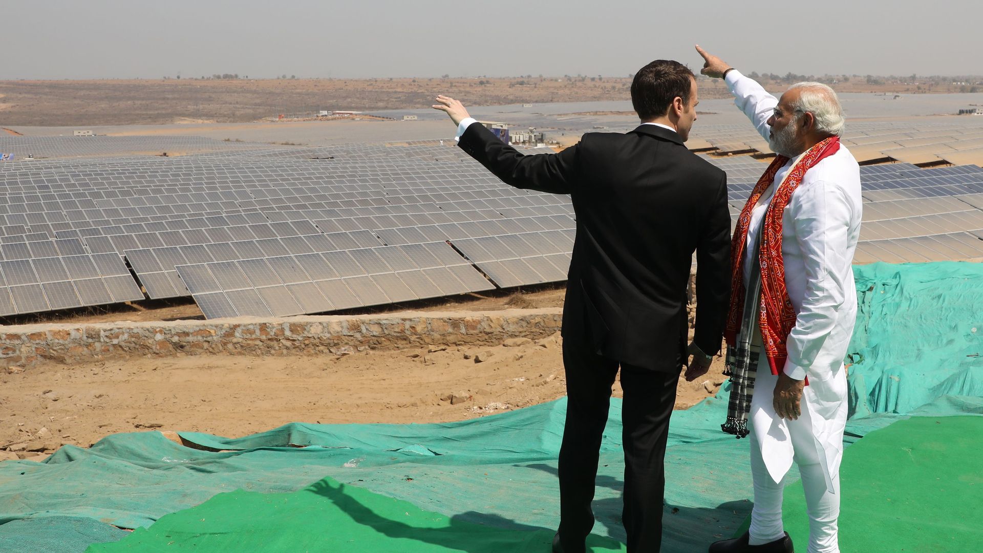 Indian Prime Minister Narendra Modi and French President Emmanuel Macron stand together during the inauguration of a solar power plant in Mirzapur in Uttar Pradesh state on March 12, 2018. 