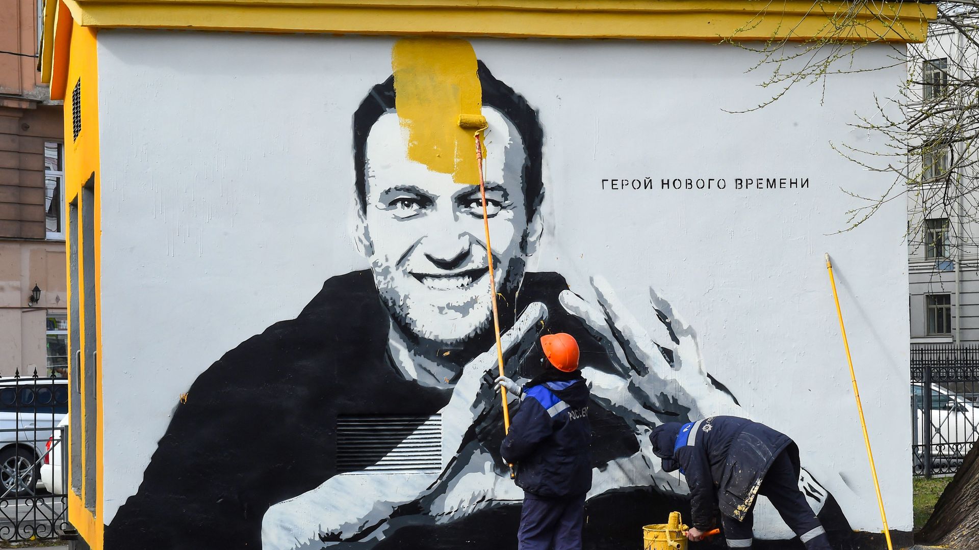 Worker painting over Navalny mural