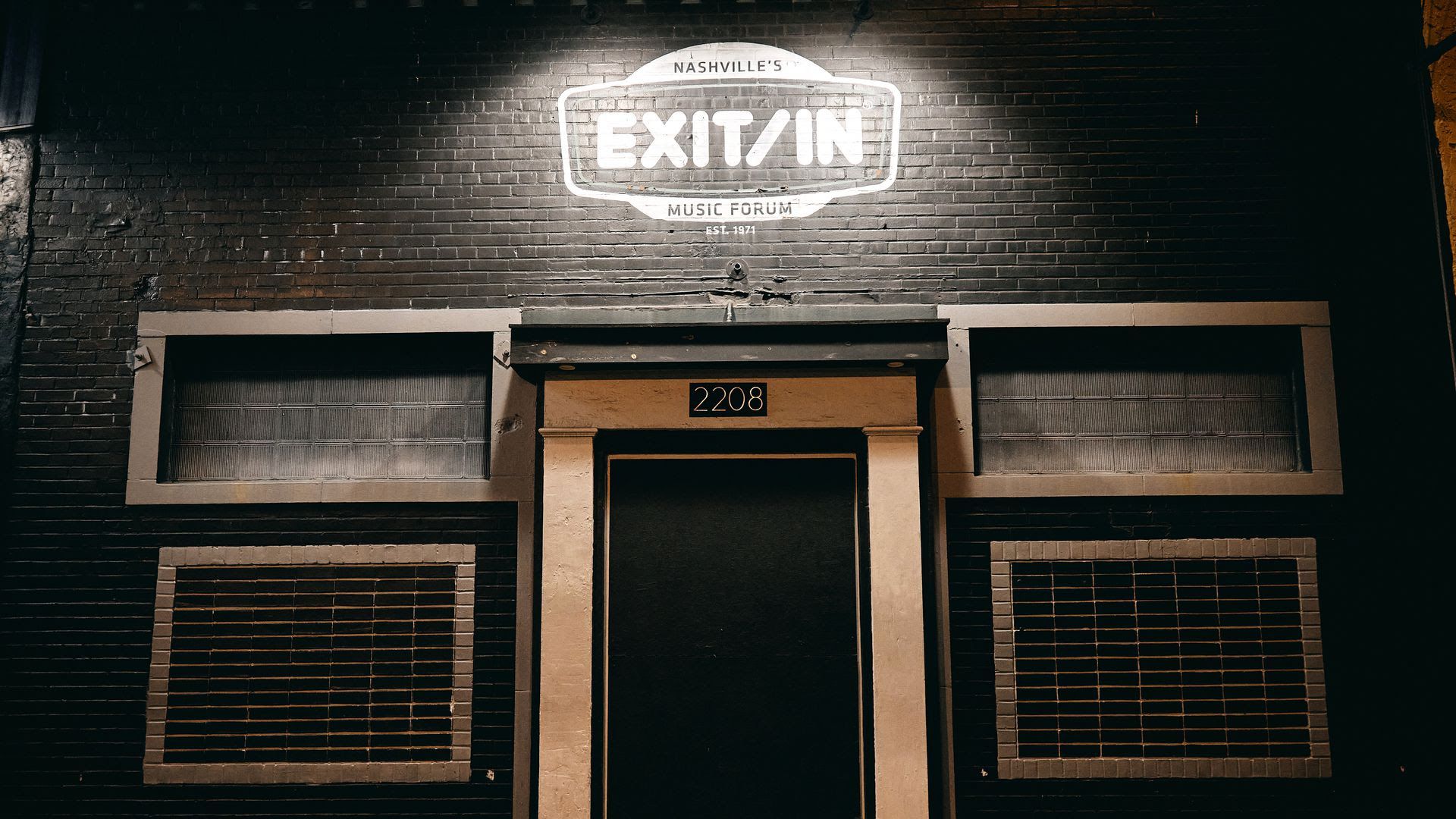 The exterior of Exit/In at night. 