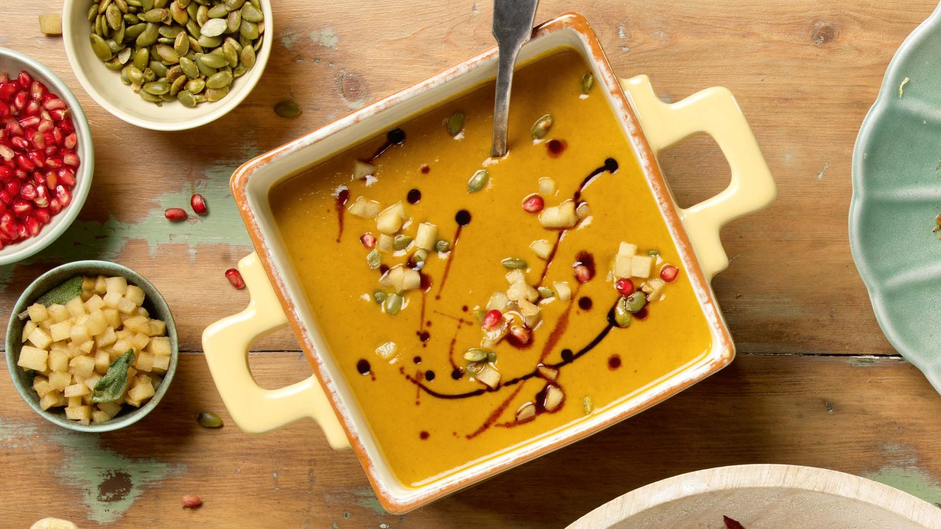 pumpkin pesto on a table with pepitas and pomegranate seeds