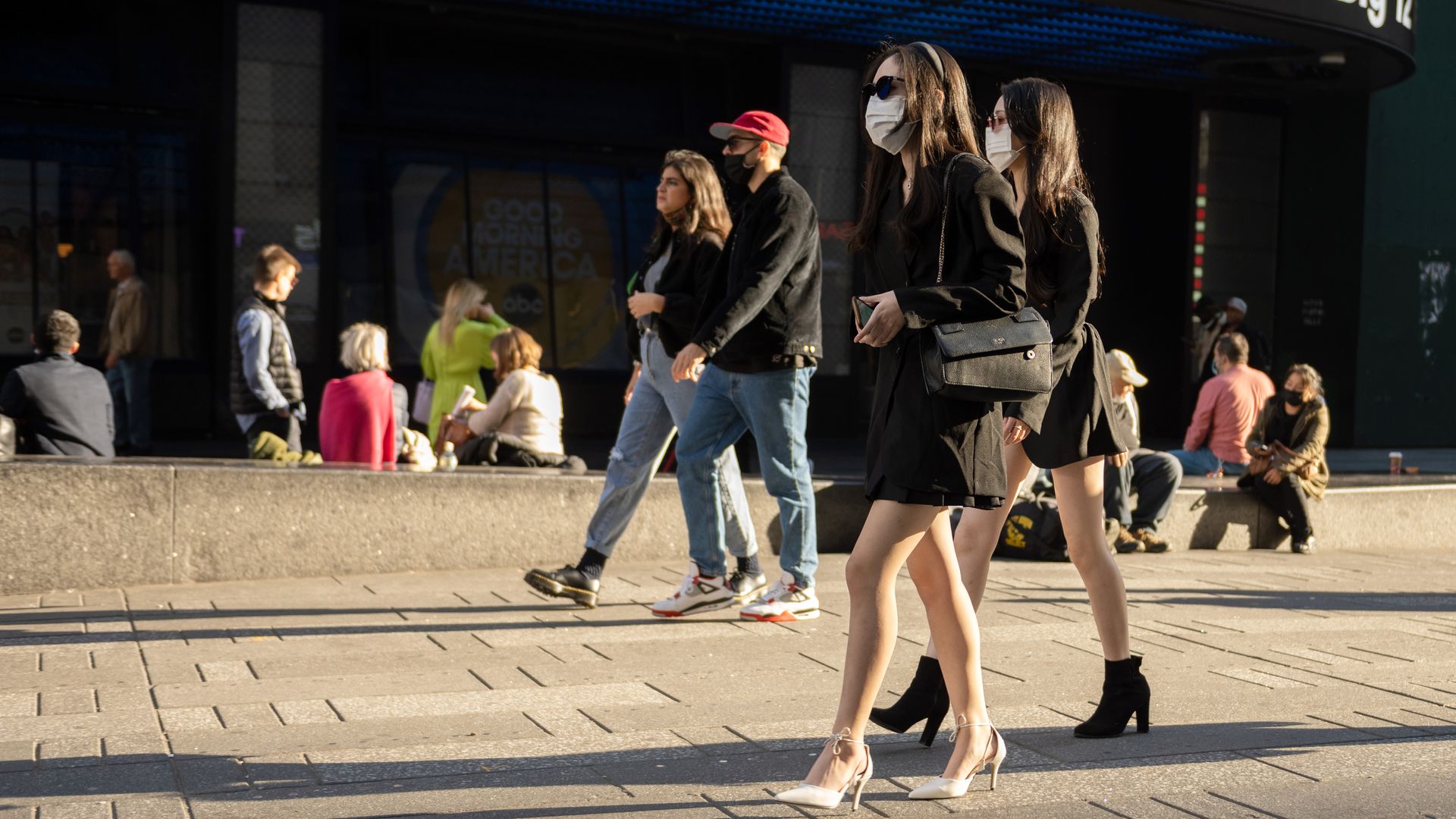 People wearing masks walking in Times Square.