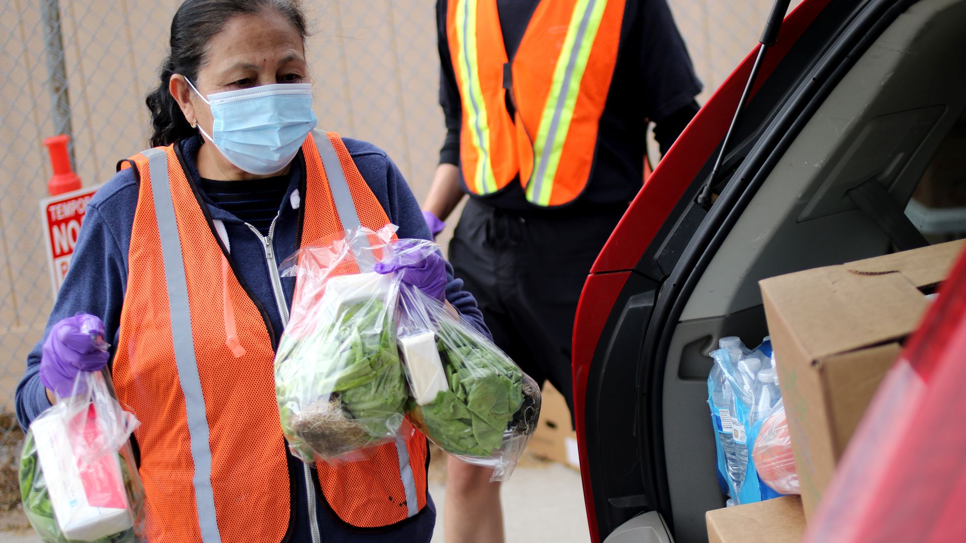 A volunteer at a food bank in Santa Barbara County, California, carries groceries, April 2021. 