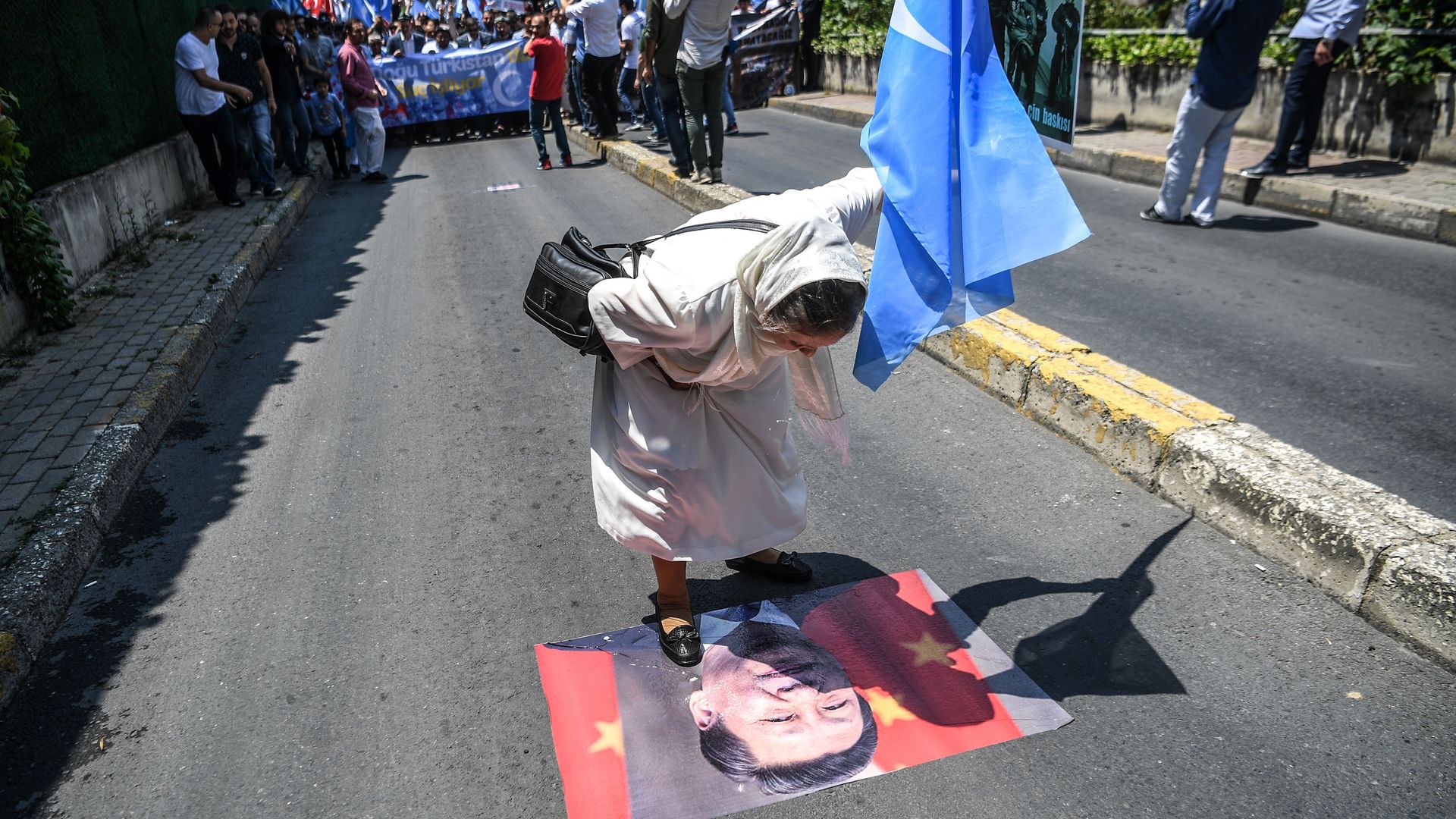 Protestor spits on a poster of Chinese President Xi Jinping during a protest of supporters of the mostly Muslim Uighur minority and Turkish nationalists. Photo: Ozan Kose/AFP/Getty Images