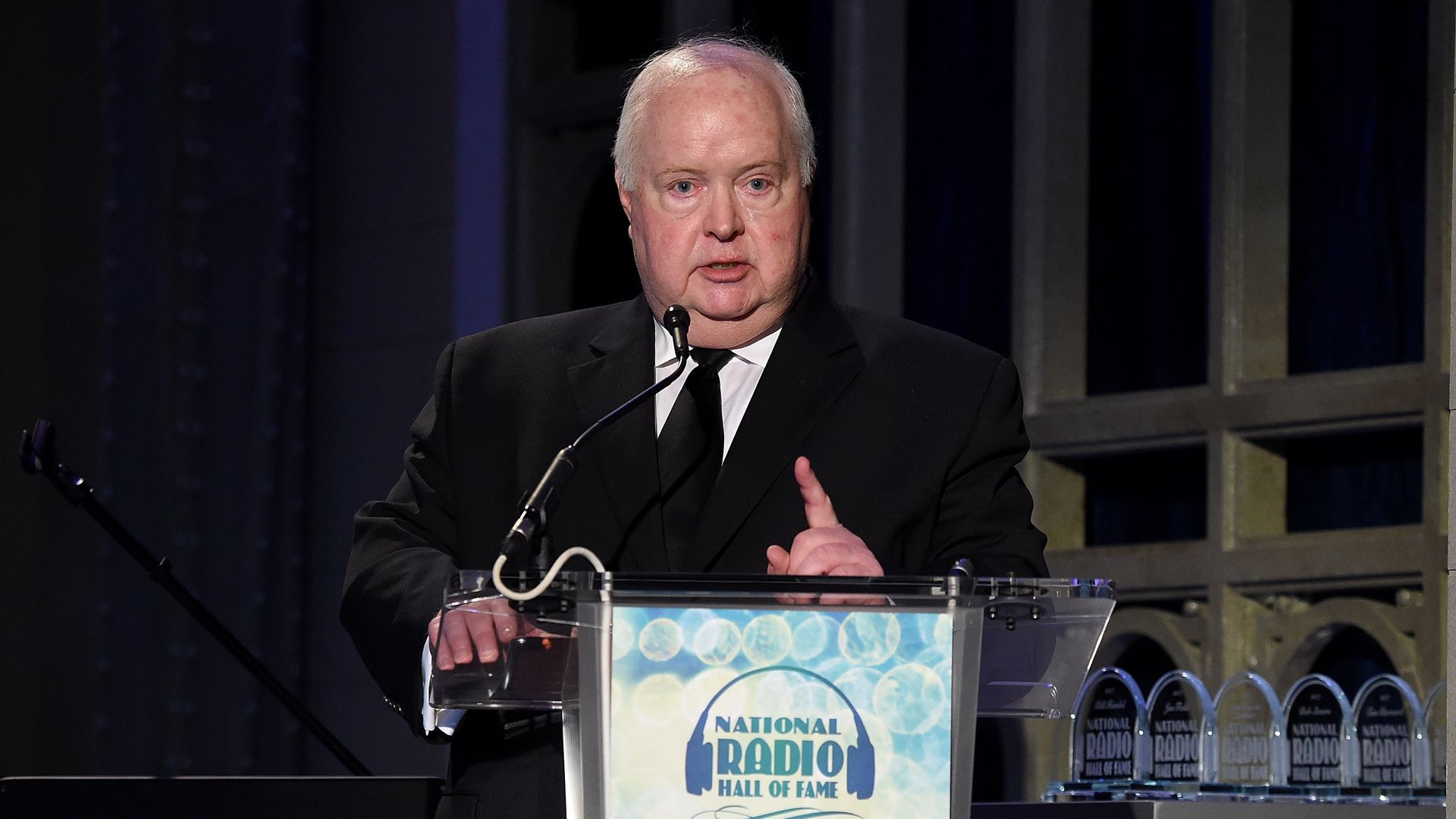 Photo of a man standing behind a podium making a speech