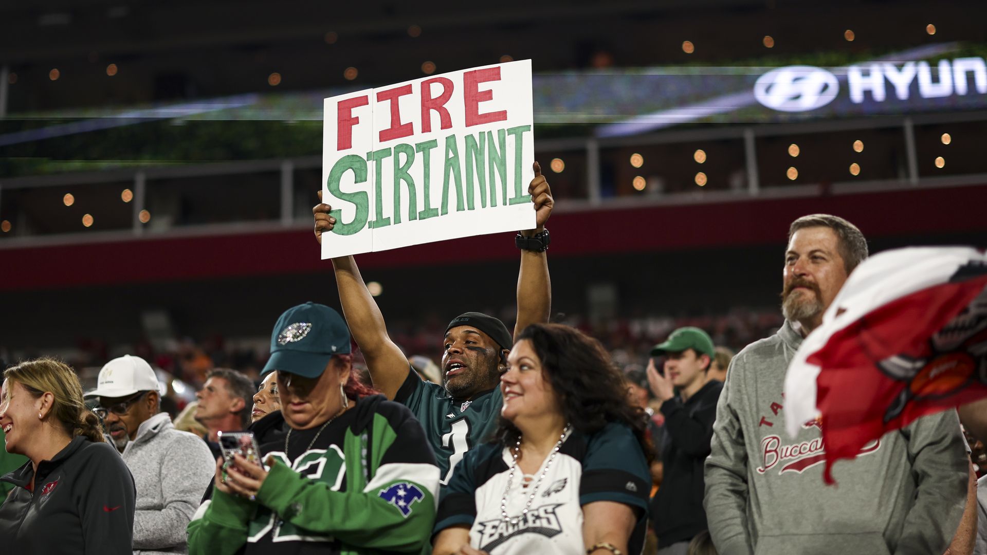 A Philadelphia Eagles fan holds up a sign reading "Fire Sirianni" during the Eagles' playoff loss.