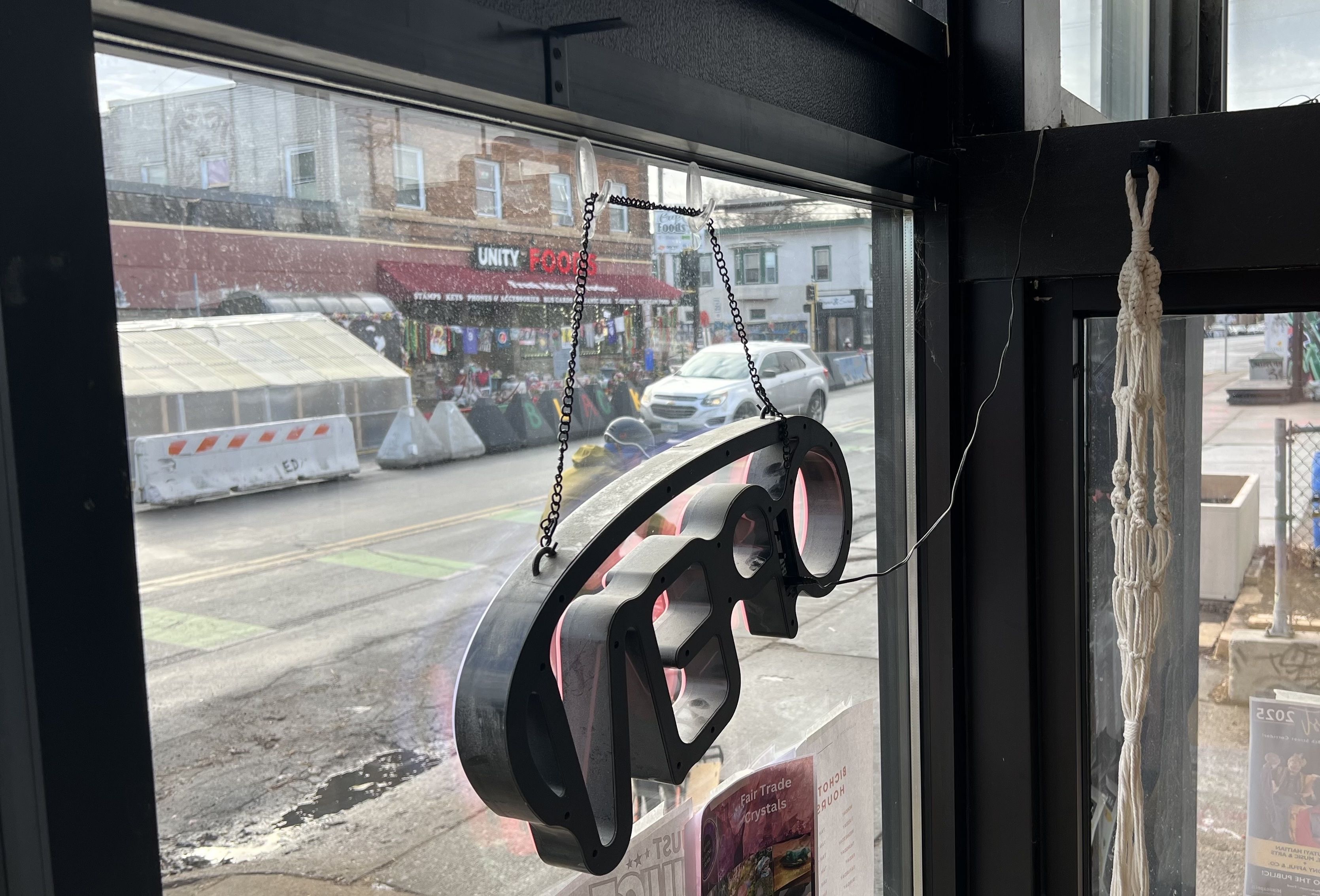 An "open" neon sign hangs in the window of a business facing the memorial to George Floyd