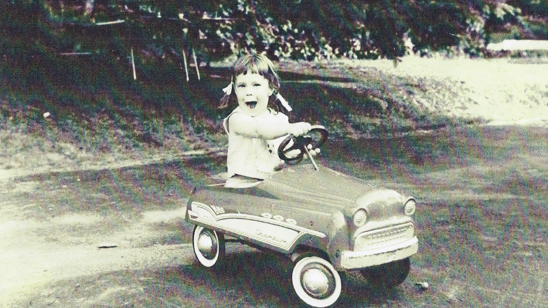 Image of the author as as a child pedaling a 1960s-era pedal car. 