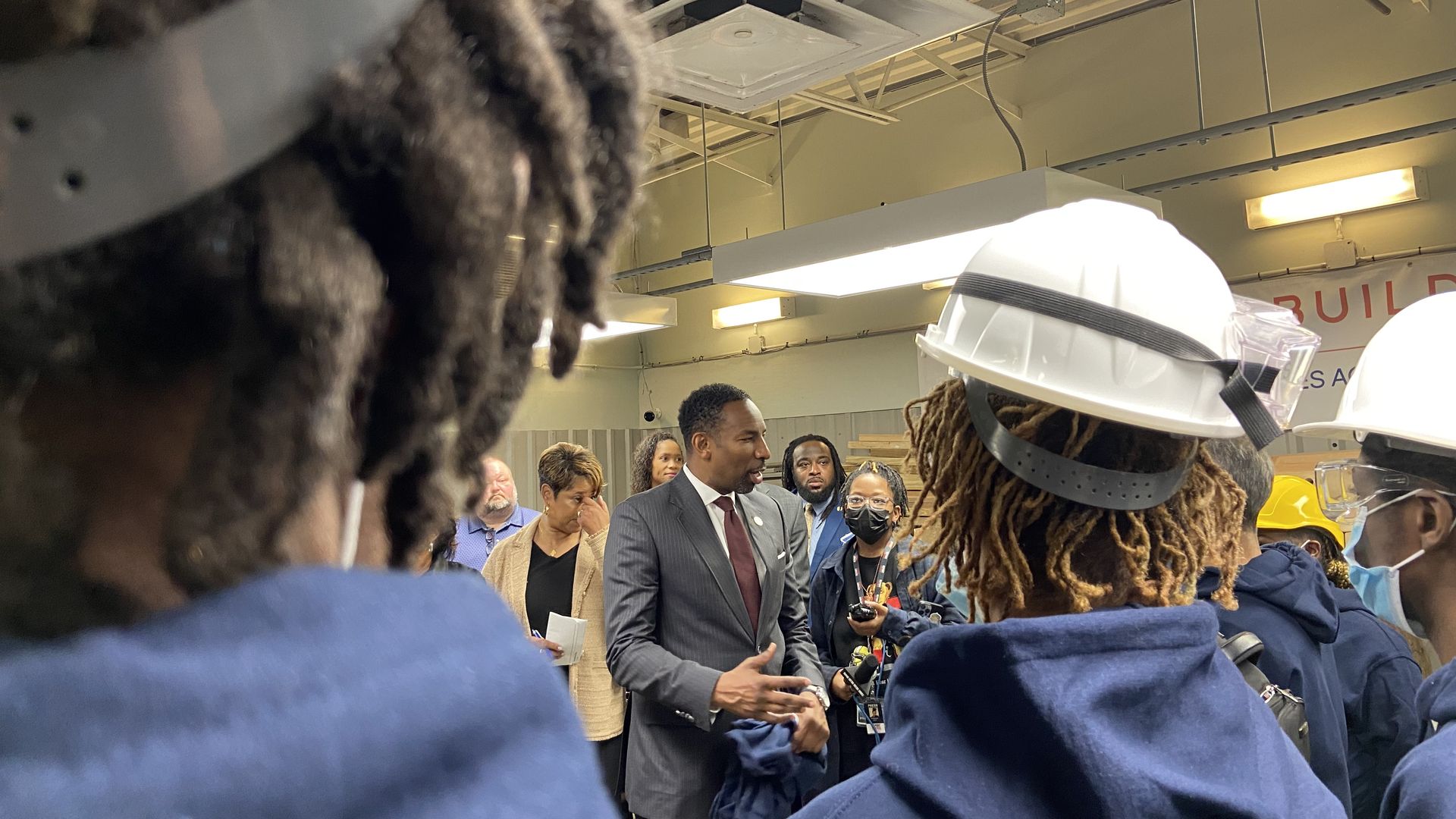 Mayor Andre Dickens stands and speaks with young people training to become welders and construction workers