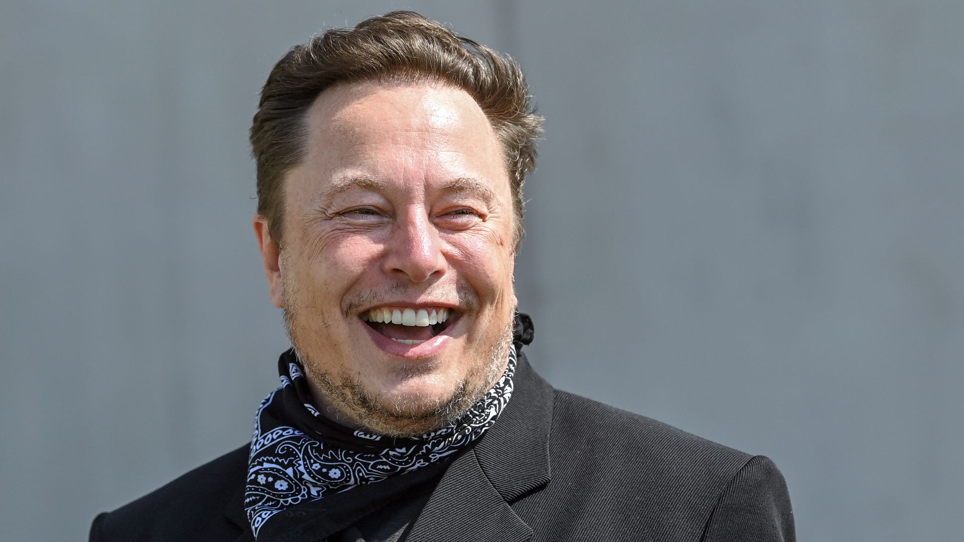 Elon Musk stands at a press event on the grounds of the Tesla Gigafactory.