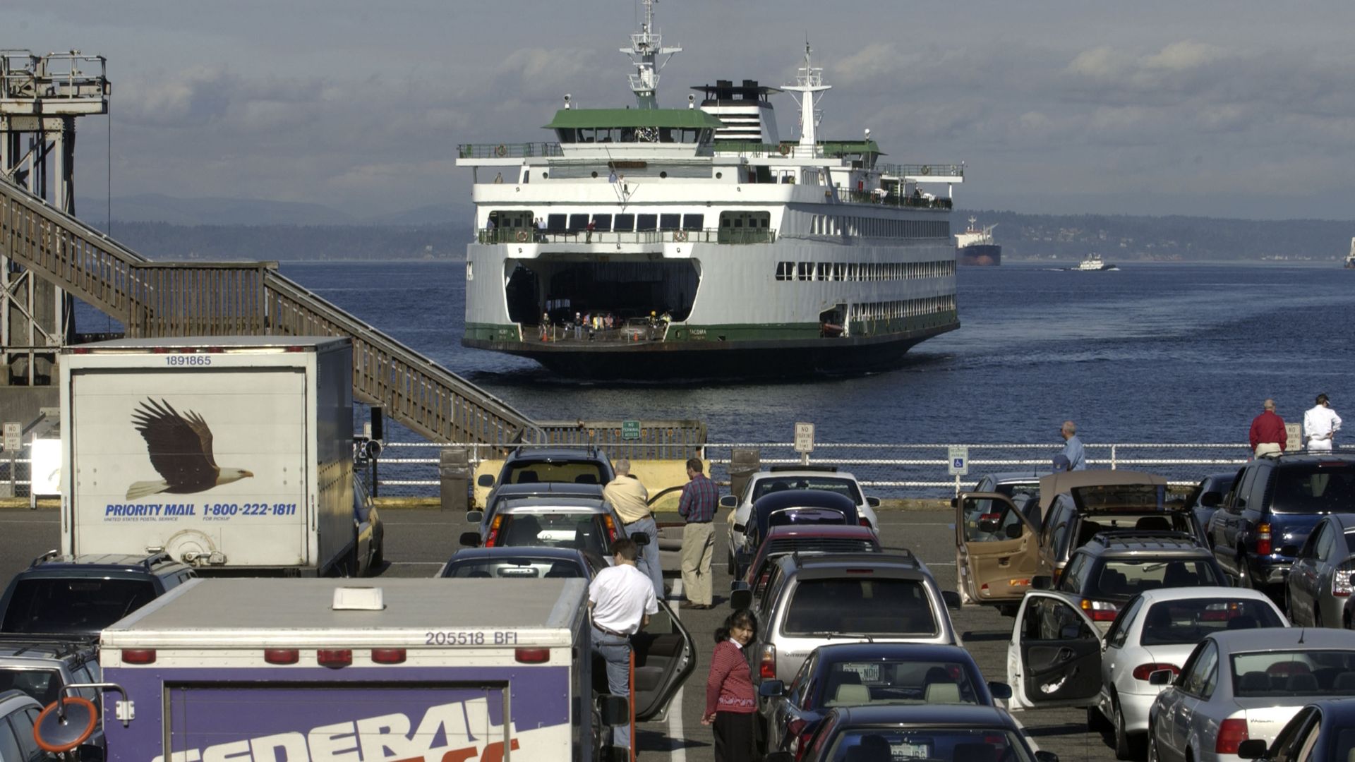 A green and white ferry pulls into the dock in Seattle 