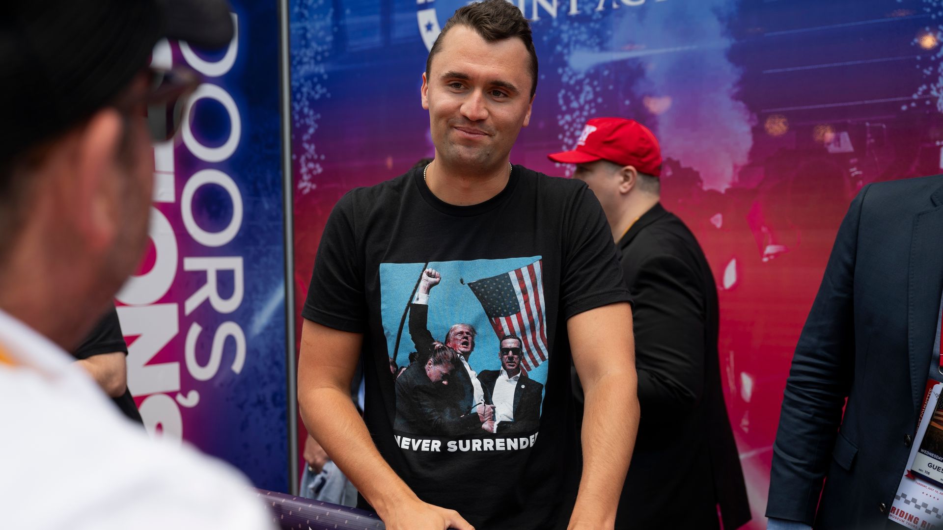 Conservative activist Charlie Kirk, wearing a black T-shirt with President Trump's image on it, talks with someone outside the Republican National Convention last year in Milwaukee.