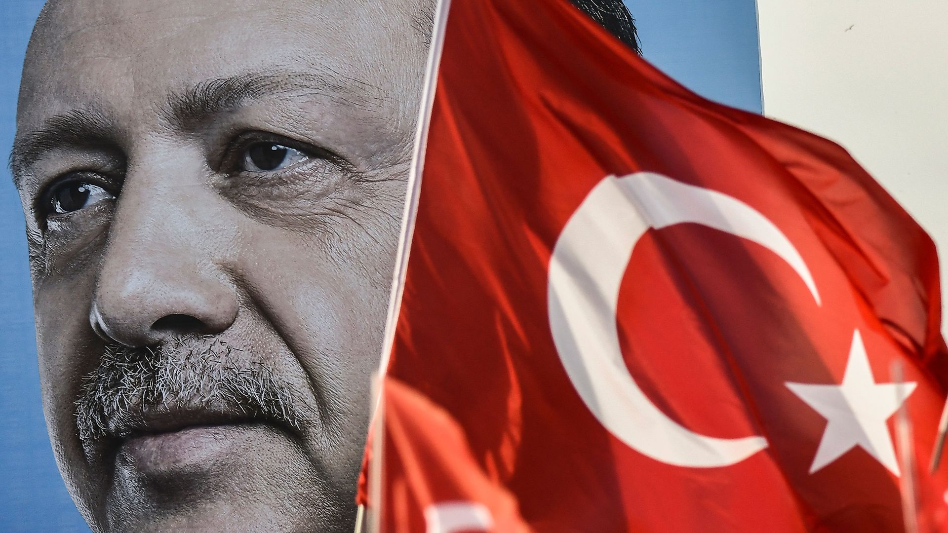 A giant campaign poster of Turkey's President Erdogan next to a Turkish flag.