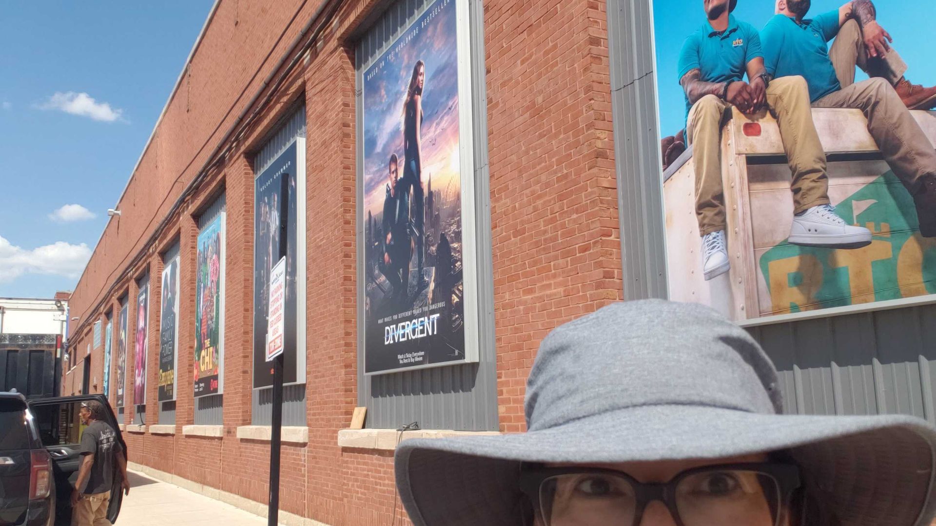 Person in front of many movie and tv posters