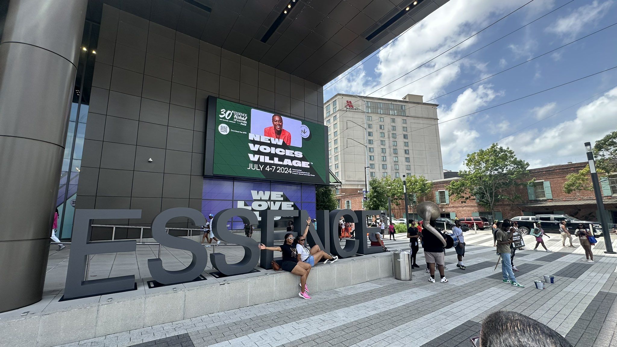 Photo shows people taking pictures with the Essence sign.