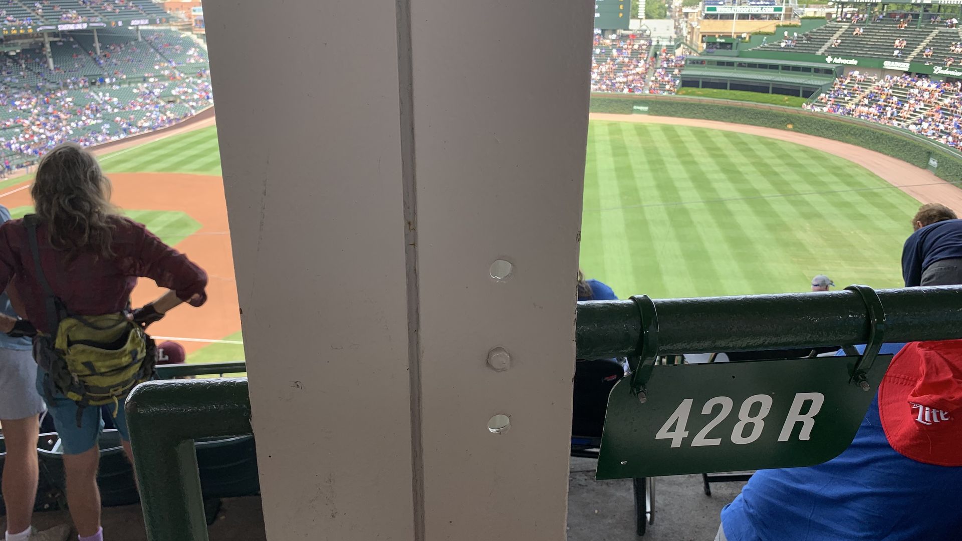 Photo of a girder blocking the view of a baseball field. 