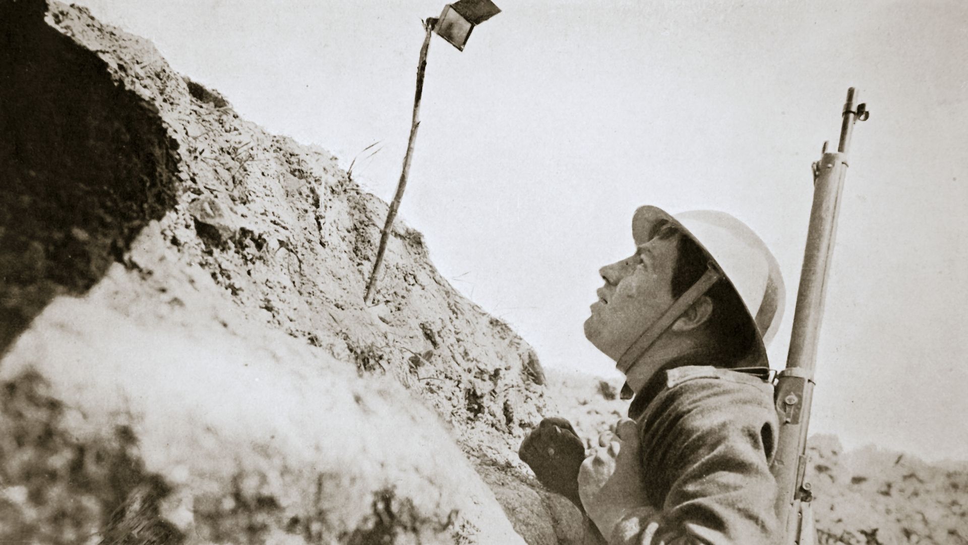 Photo of a soldier looking at a mirror on a stick