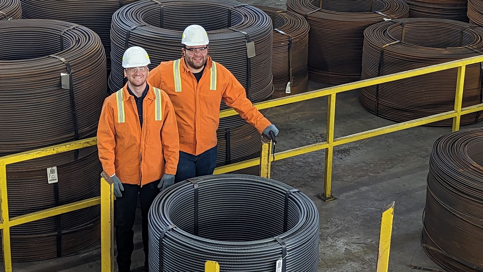 The founders of startup Allium standing behind their stainless steel coated rebar.