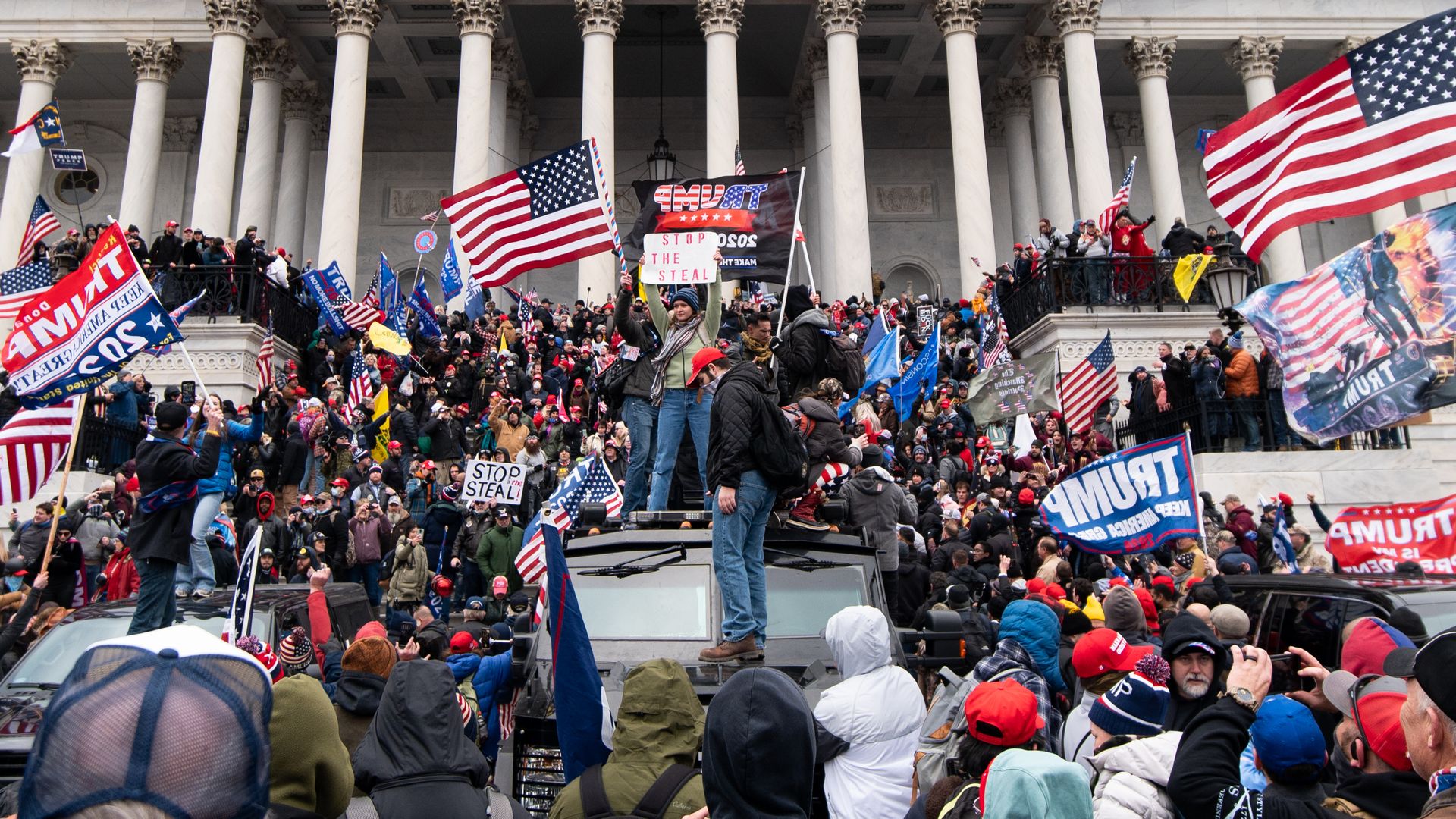 Photo of a mob of Trump supporters crowded onto the steps of the Capitol with signs and banners