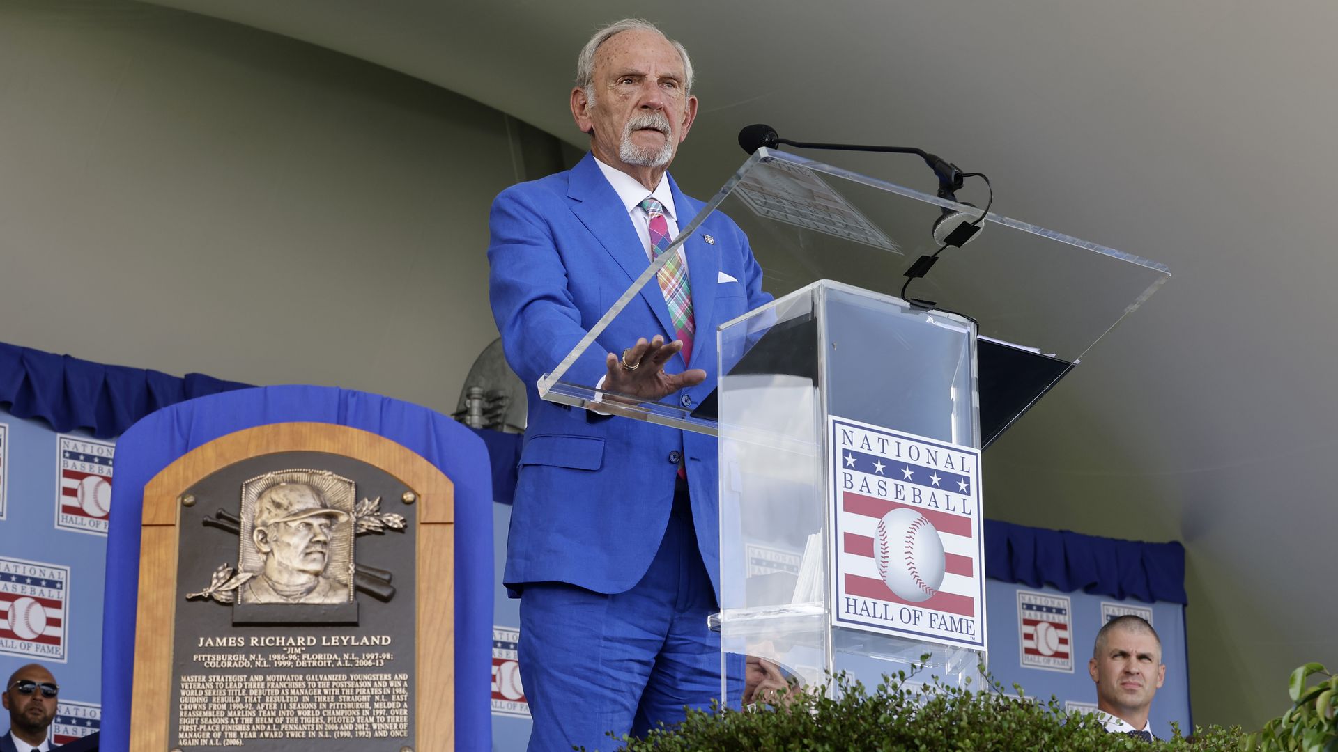 Jim Leyland stands at a podium looking out over the crowd, wearing a blue suit.