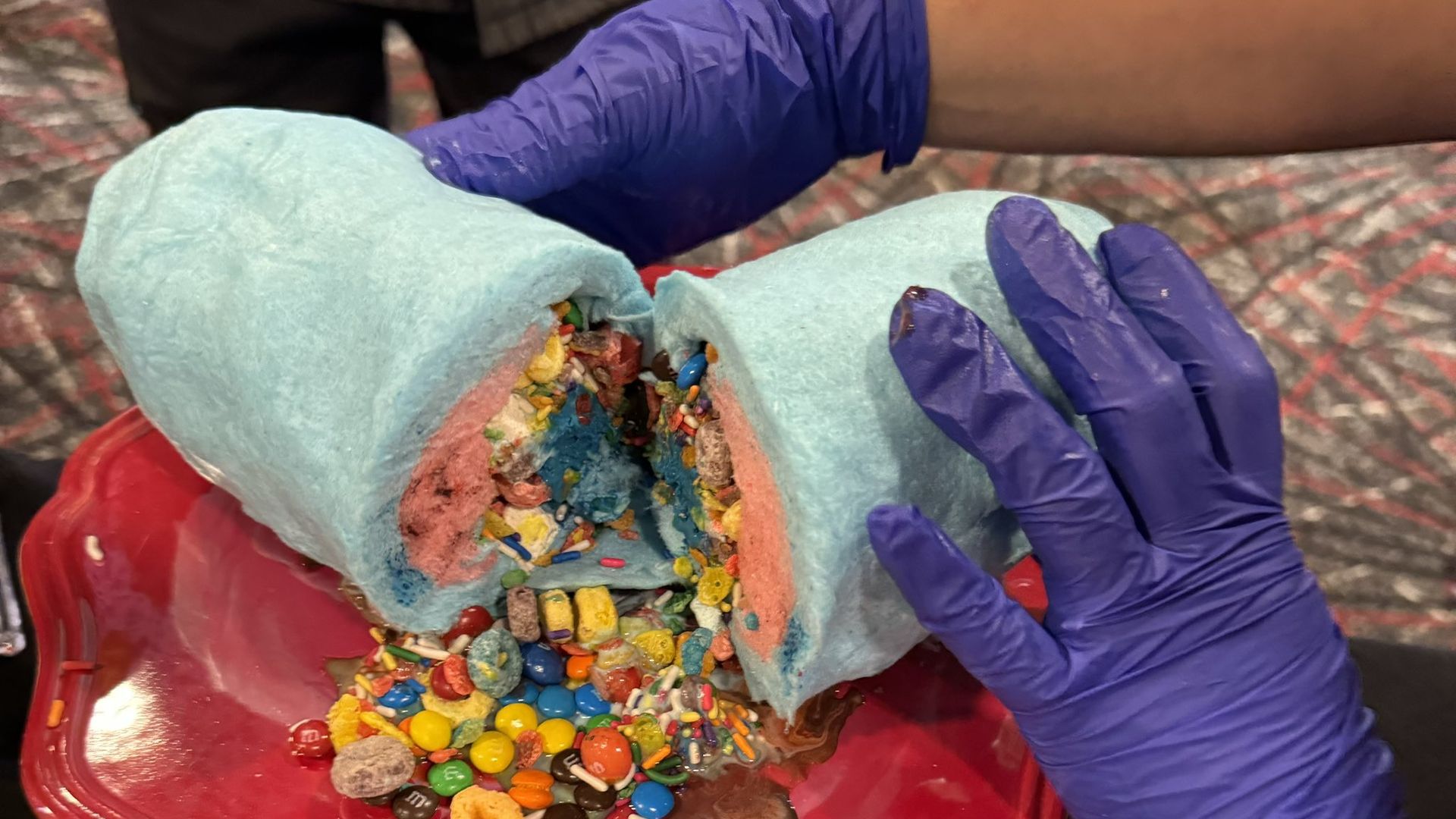 Ice cream and candy wrapped in blue cotton candy to resemble a burrito. 