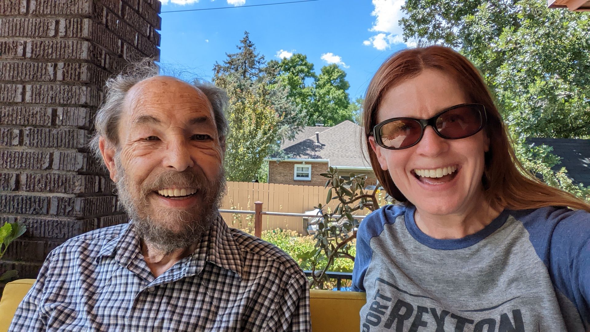 A 74-year-old man and a 53-year-old woman sit on a porch swing together.