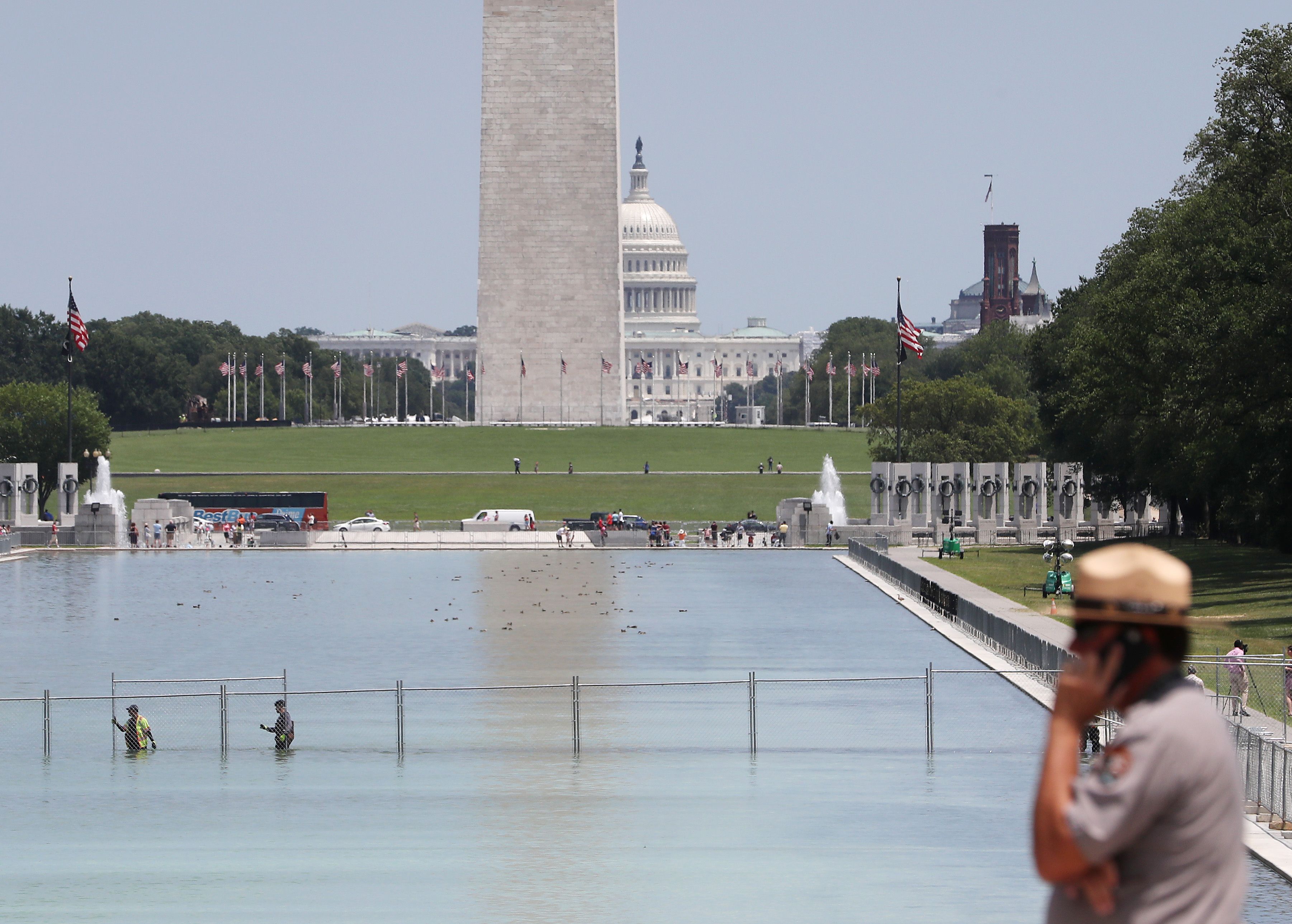 Workers install a security fence in the Reflecting Pool in front of the Lincoln Memorial ahead of the Fourth of July "Salute to America" celebration.