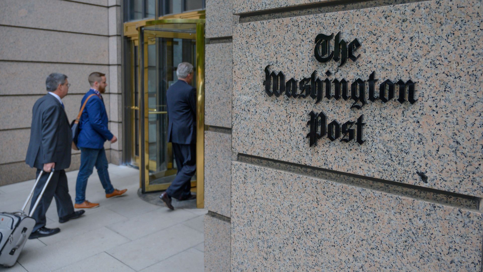 People walk into The Washington Post building.