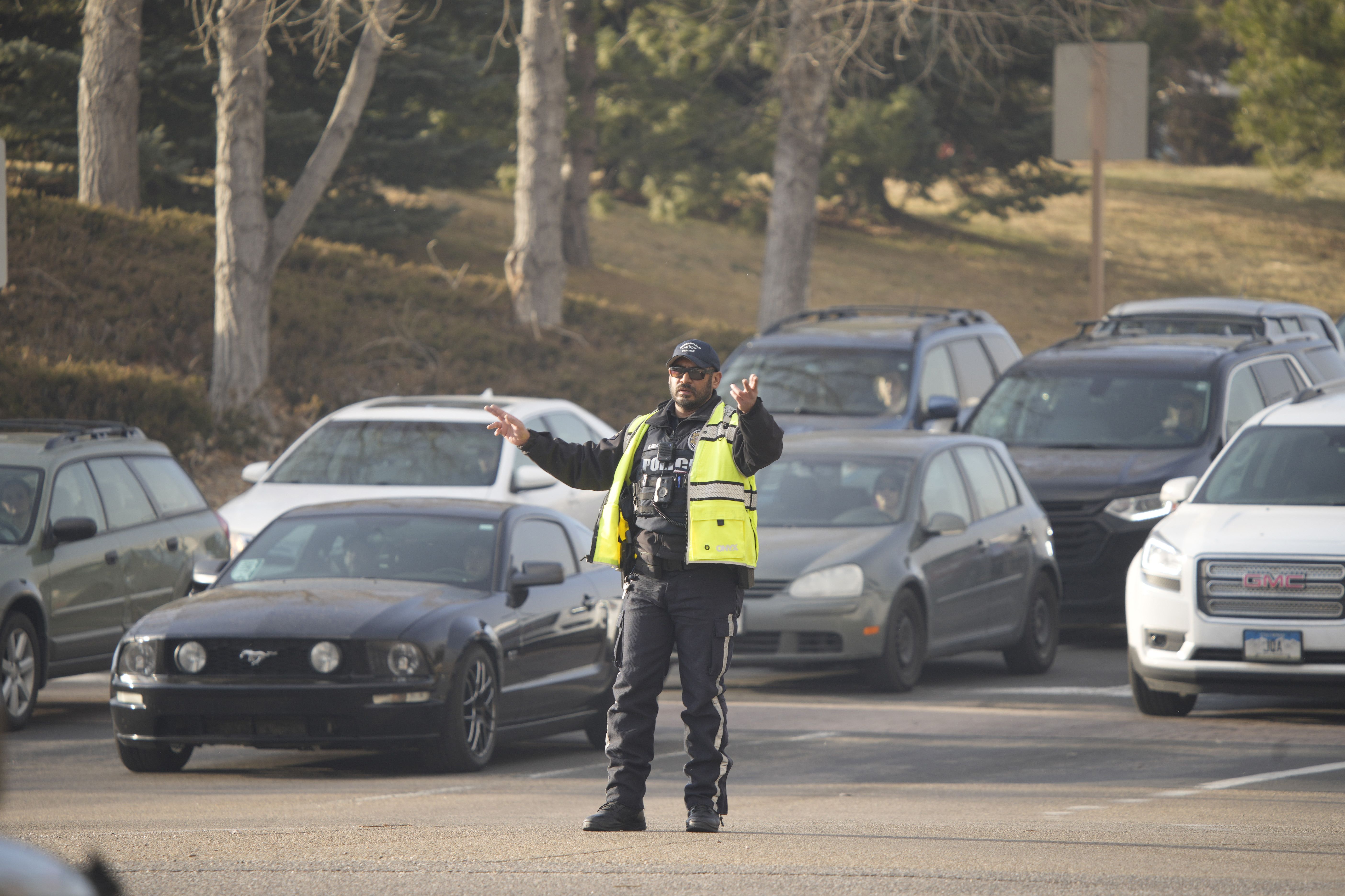 A Brookfield Police officer directs motorists out of the parking lot of Flatiron Crossing Mall as wildfires burned near the shopping center.