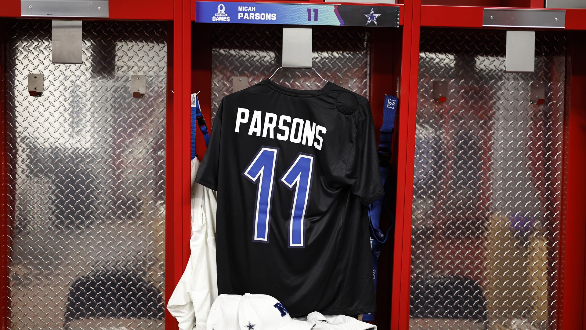 A black and blue jersey hangs in a red locker room