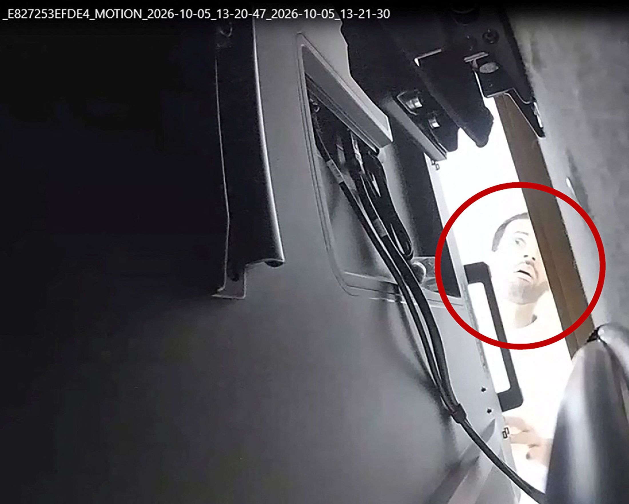 A man identified as Abdulrahman Alfozan, a Saudi national employed as an OpenAI engineer, looks behind a TV where a recording device had been hidden in an OpenAI conference room.