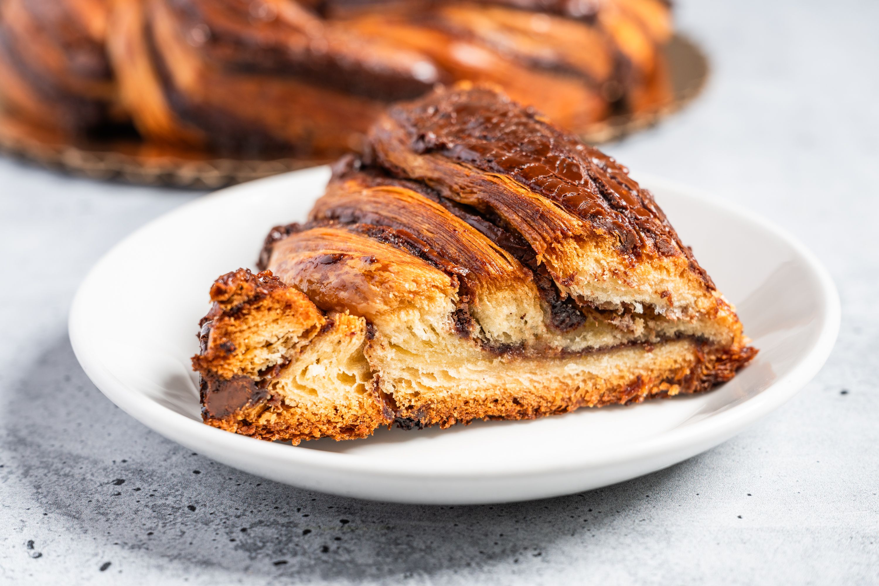 Photo shows a slice of king cake on a white plate