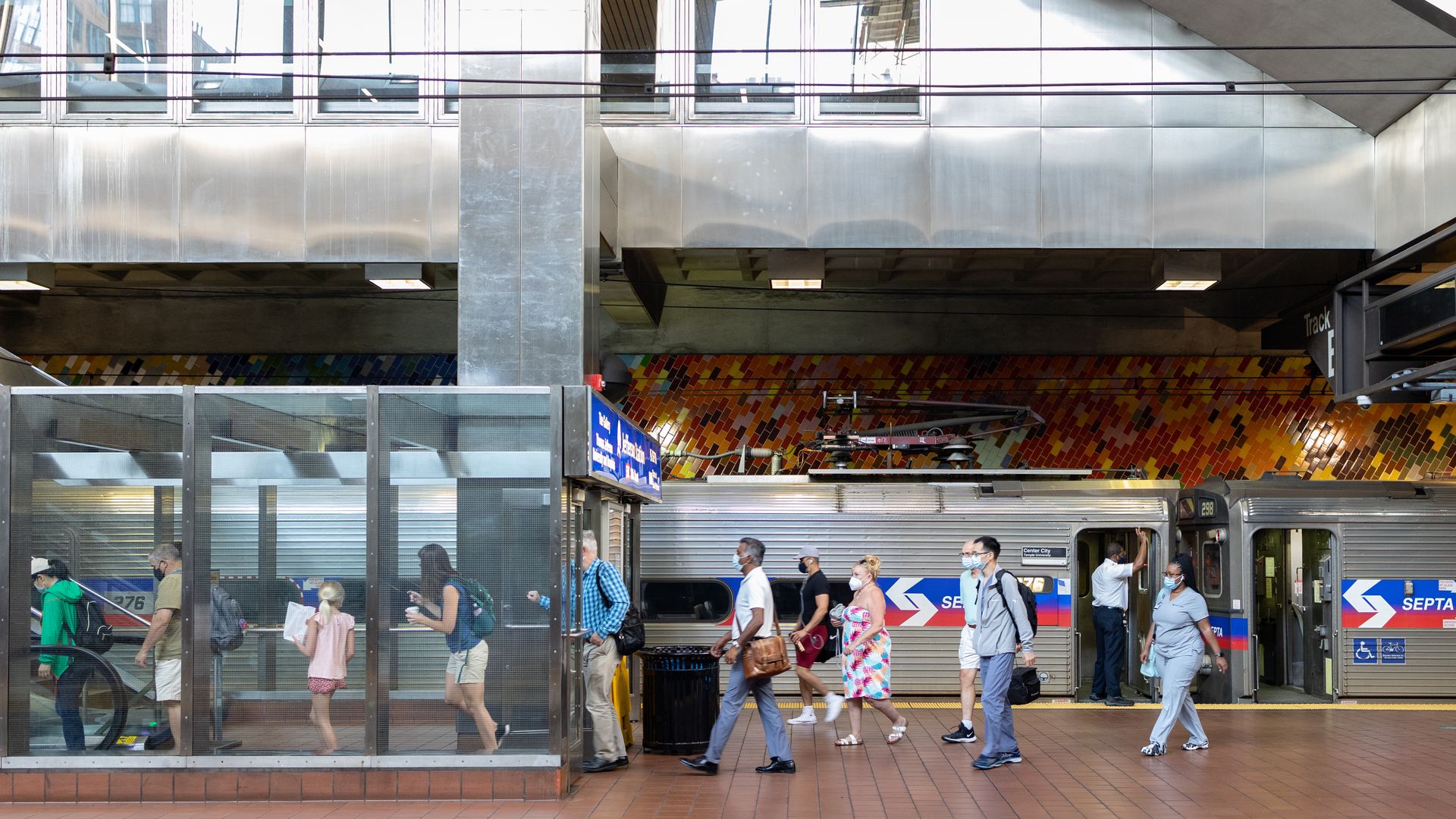 Riders on SETPA walk on the platform beside a subway. 