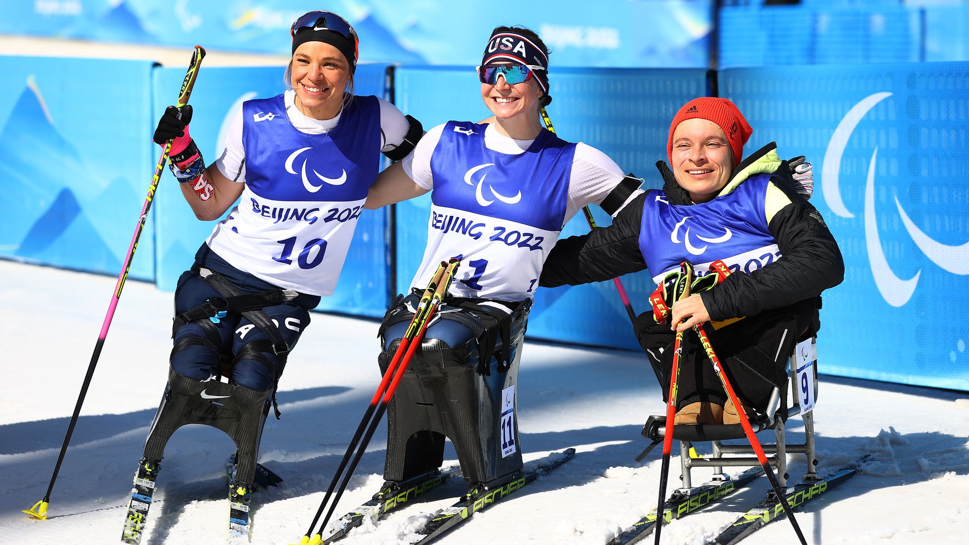 Team USA's Oksana Masters, Kendall Gretsch and bronze medalist Anja Wickers of Team Germany at the Para Biathlon Women's Middle Distance Sitting flower ceremony March 8 in China.
